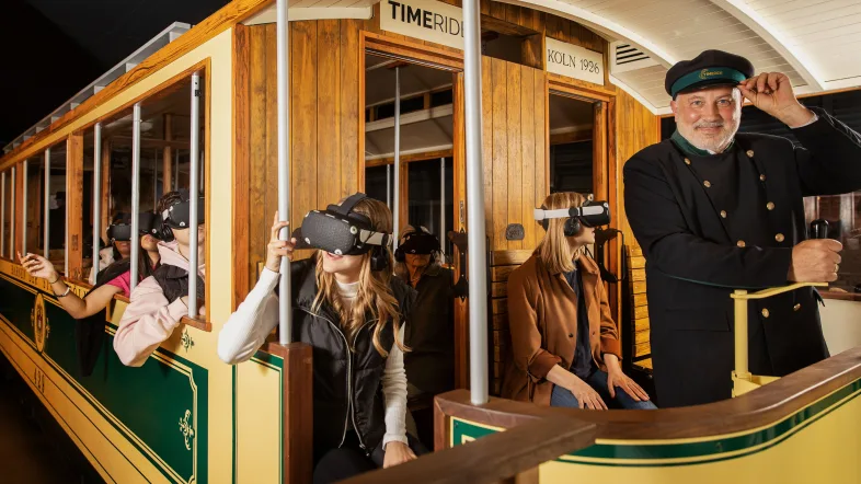 Personen mit VR-Brillen in historischer Straßenbahn