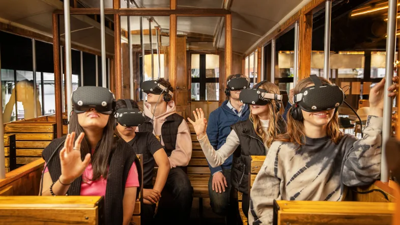 Personen mit VR-Brillen in historischer Straßenbahn
