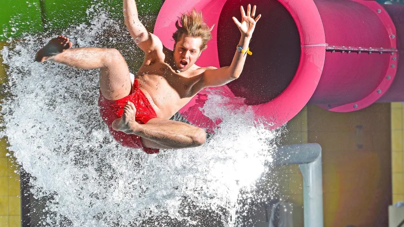 Junge kommt aus der Pink Jump Rutsche