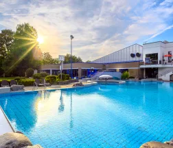 Außenpool des Aquarius Borken bei Sonnenschein mit glitzerndem Wasser und Liegeflächen.