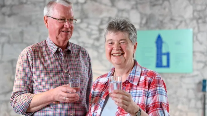 Ein Paar im Aquarius Mülheim mit einem Glas Wasser in der Hand.