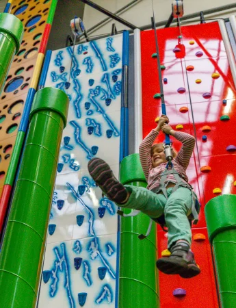 Kind hängt an einem Sicherungsseil im EasyClimb Essen.
