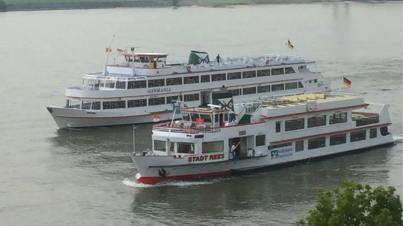 Fahrgastschiffe Rees und Germania fahren nebeneinander über den Rhein