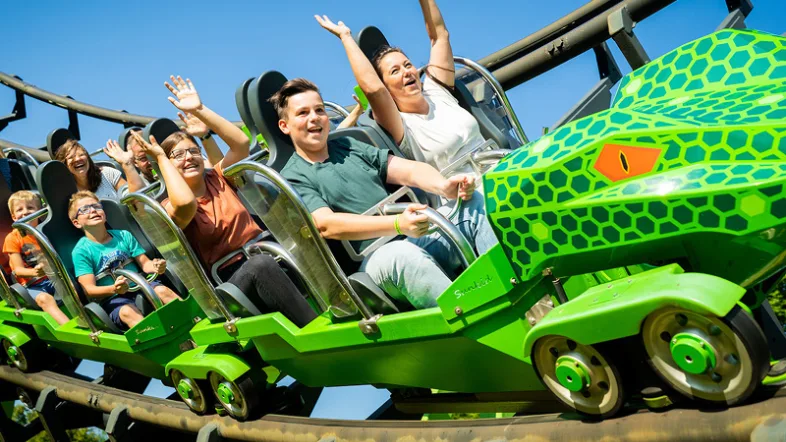 fröhliche Menschen in grüner Achterbahn