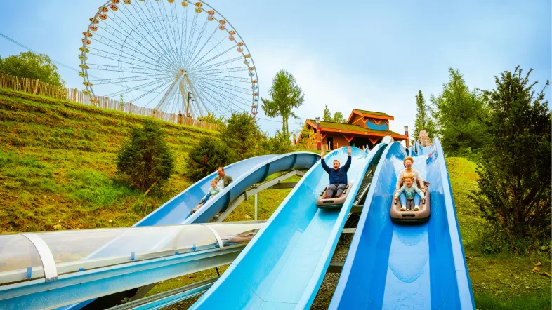Menschen auf langer blauen Rutschbahn