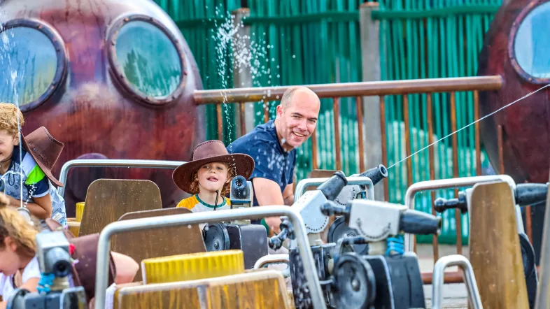 Vater spielt mit seinem Sohn auf dem Wasserspielplatz im Freizeit- und Ferienpark Slagharen.