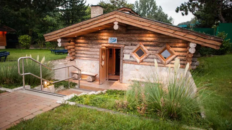 Außenansicht der Erdsauna im Revierpark Vonderort, eingebettet in grüne Natur und leicht bewachsen.