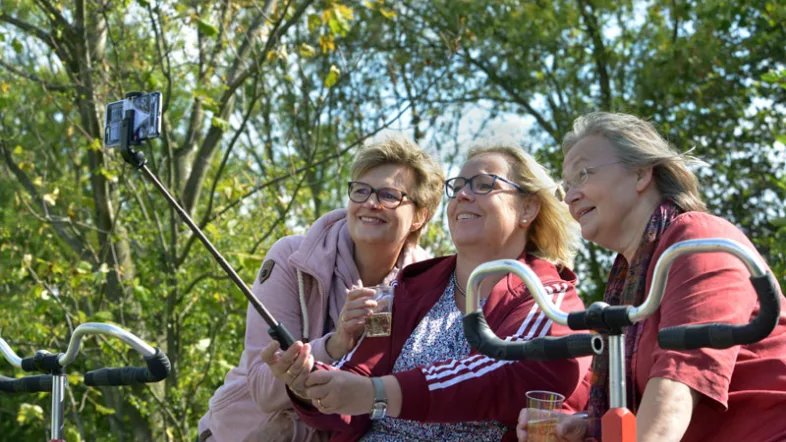 Freunde nehmen ein Selfie mit einem Selfiestick auf auf der Fahrt mit der Grenzlanddraisine.