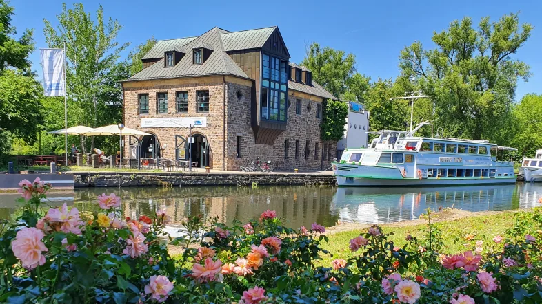 Außenansicht des Haus Ruhrnatur in Mülheim mit blühenden Rosen im Vordergrund.