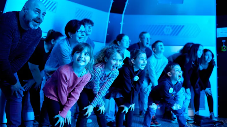 Eine Gruppe von Menschen in blauem Licht beim HOUSE OF MAGIC - powered by Ehrlich Brothers in Oberhausen.