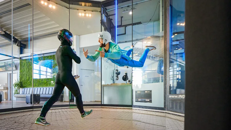 Gruppe von Freunden in Fluganzügen lächelt gemeinsam bei Indoor Skydiving Bottrop.