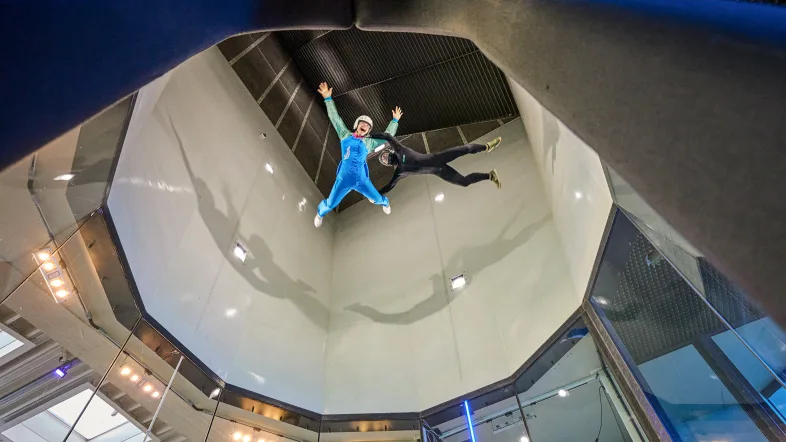 Person schwebt in der Flugkammer beim Indoor Skydiving in Bottrop in horizontaler Flugpose.