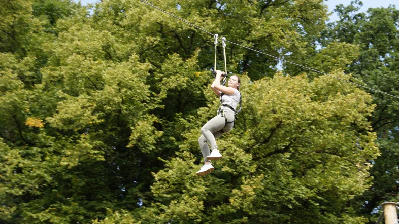 Teilnehmer fährt mit der Seilbahn durch den Kletterpark am Biggesee.