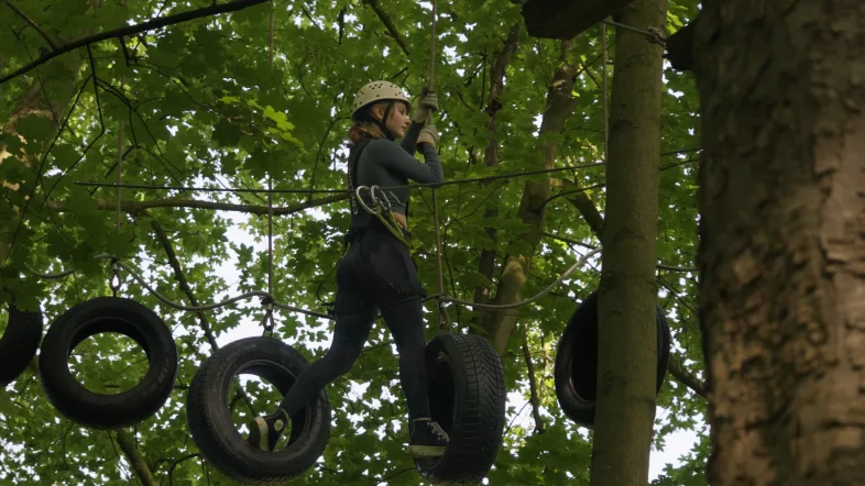 Person klettert durch einen Reifen-Parcours im Kletterpark Hamm.