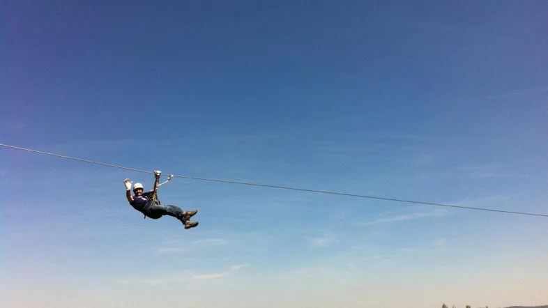 Besucher fährt mit der Seilbahn über die Baumkronen im Kletterpark Hamm.