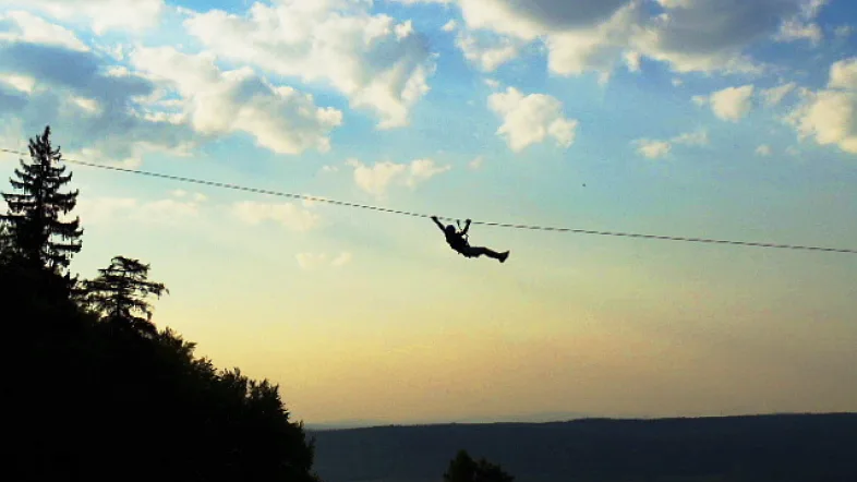 Besucher fährt mit der Seilbahn über die Baumkronen im Kletterpark Hamm.