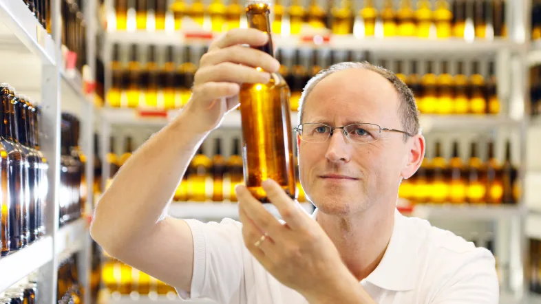 Mann hält ein Bier in der König-Brauerei Duisburg.