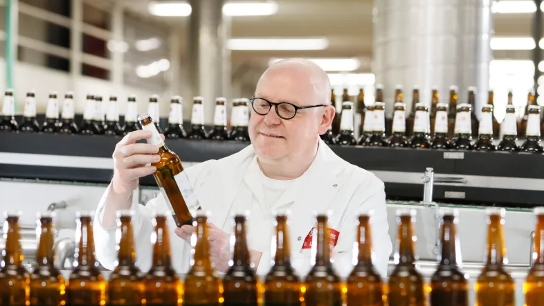 Fließband in der König-Brauerei Duisburg mit vorbeifahrenden Bierflaschen.
