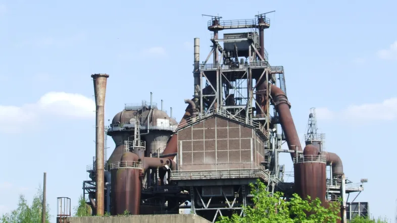 Hochofen im Landschaftspark Duisburg-Nord, umgeben von grüner Parklandschaft.