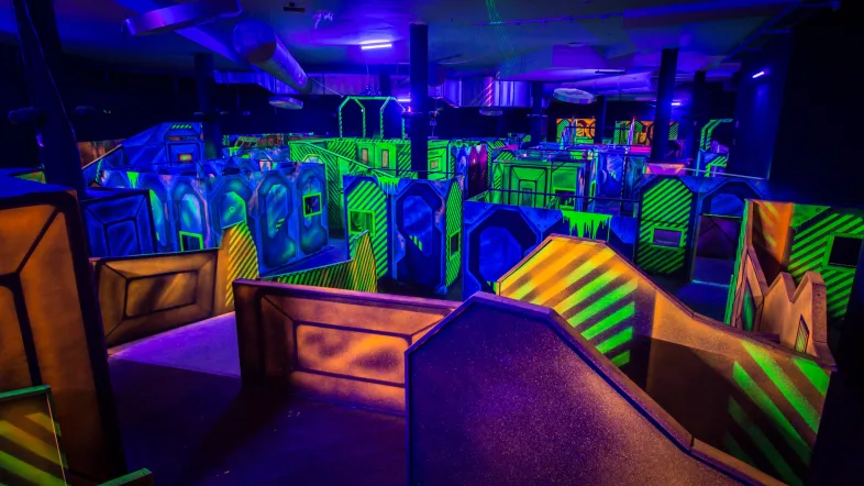 Panoramablick auf die Spielfläche der Laserzone Essen mit Neonlichtern und Hindernissen