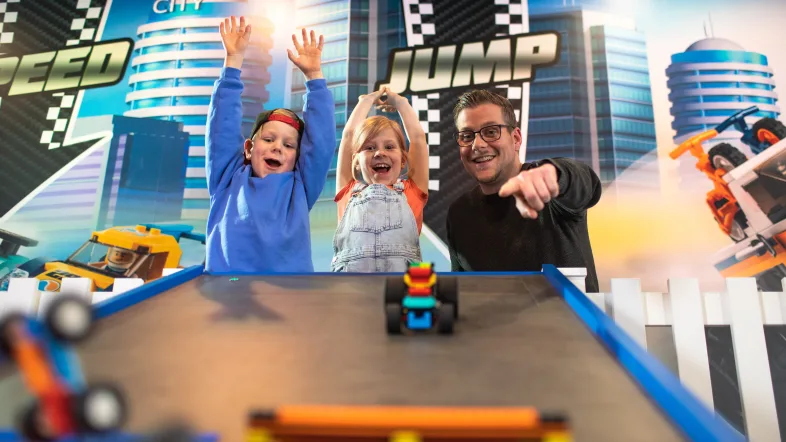 Zwei Jungs spielen zusammen mit ihrem Vater im Legoland Oberhausen.