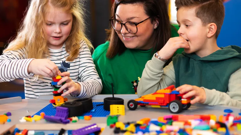 Mutter spielt mit ihren Kindern im Legoland Oberhausen.
