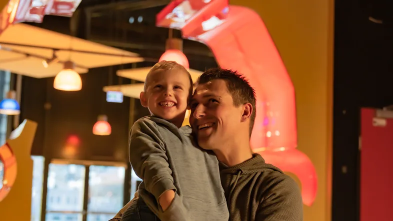 Vater trägt seinen Sohn auf dem Arm im Legoland Oberhausen.
