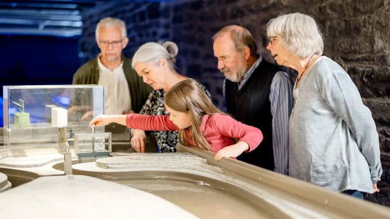 Eine Gruppe von Menschen betrachtet ein Ausstellungsstück im Kraftwerk engelskirchen.