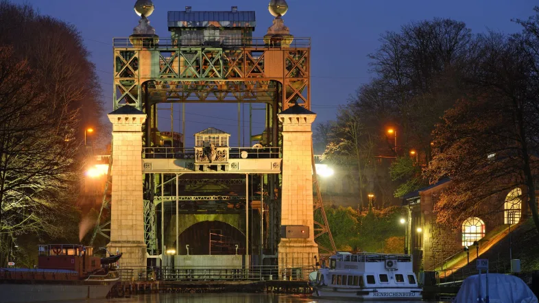 Beleuchtete Schleuse des LWL-Museum Schiffshebewerk Henrichenburg bei Nacht.