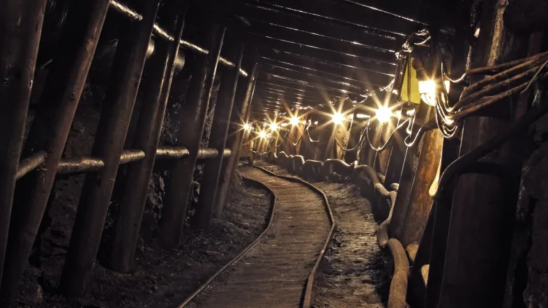 Blick in den Stollen mit Schienen am Boden.