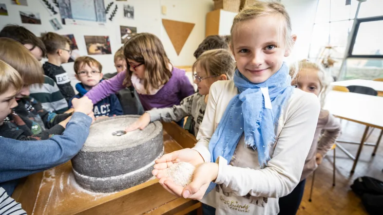 Kinder halten ihre getöpgerten Dinge in die Kamera im LWL-Römermuseum in Haltern.