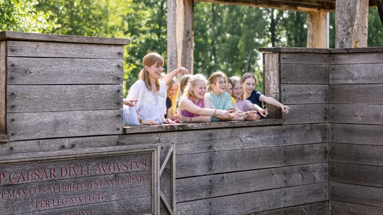 Schüler:innen auf der originalgetreuen Rekonstruktion des Westtores auf der Römerbaustelle Aliso.