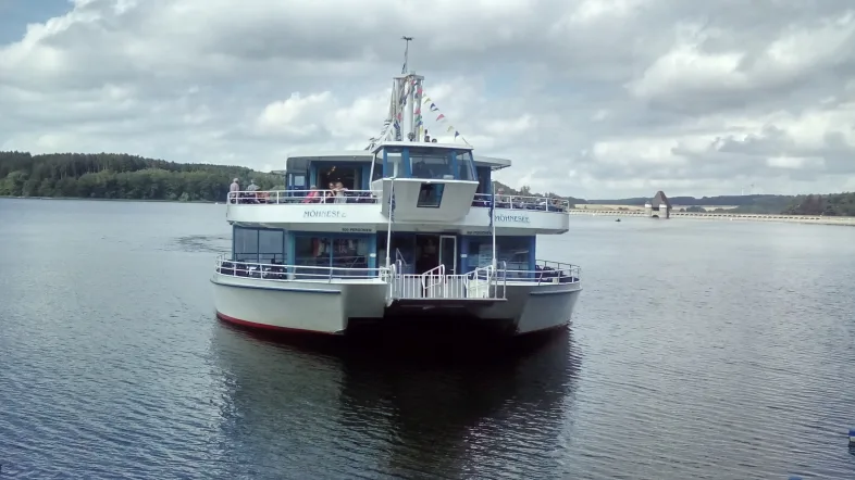 Fahrtsschiff auf dem Möhnesee, von vorne aufgenommen, gleitet ruhig über das Wasser an einem klaren Tag.