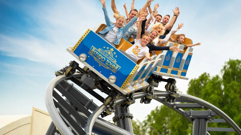 Viele Menschen in einer Achterbahn halten ihre Hände in die Luft im Movie Park Bottrop.