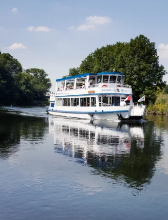 MS Schwalbe in Witten mit klarer Spiegelung im ruhigen Wasser unter blauem Himmel.