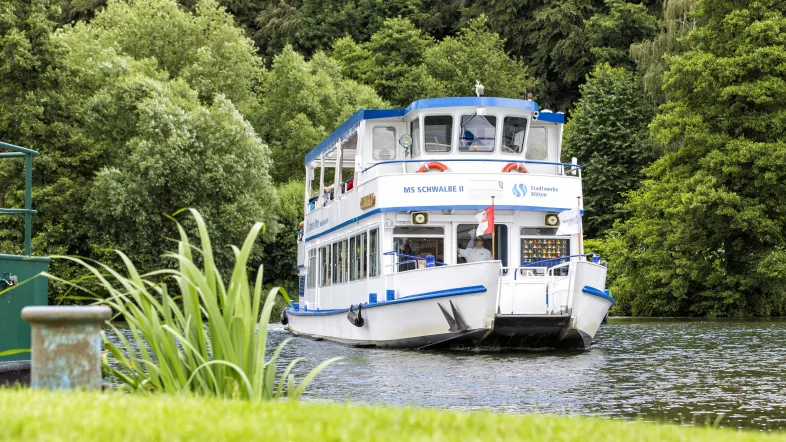 Ausflugsschiff MS Schwalbe in Witten, frontal aufgenommen auf dem Wasser mit Blick auf das Steuerhaus.