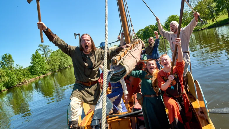 Gruppe von Leuten schreit und feiert auf dem Wikingerschiff in Mülheim an der Ruhr