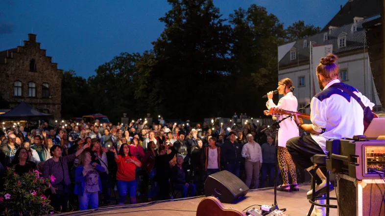 Schausteller auf der Bühne vor Publikum mit Lichtern in der Hand vor dem Haus Opherdicke.