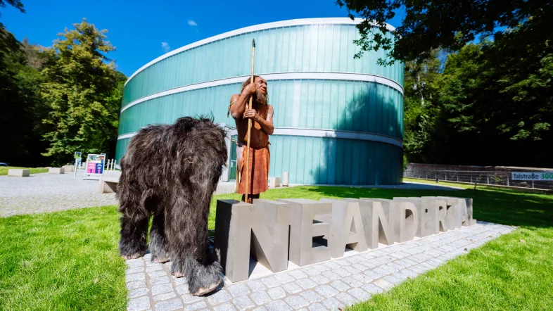 Die Neanderthaler Rekonstruktion Mister N und das Babymammut Tinka stehen vor dem Neanderthal Museum