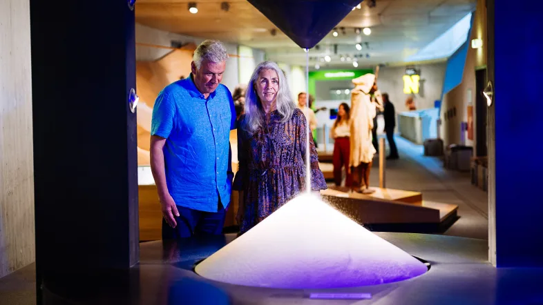 Zwei Erwachsene betrachten die Sanduhr im Neanderthal Museum