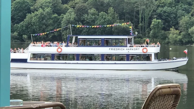 Seitenansicht des Ausflugsschiffs MS Friedrich Harkort auf dem Wasser vor der Kulisse von Witten.