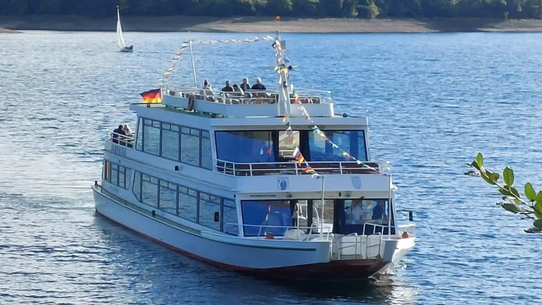 Fahrgastschiff auf dem Sorpesee, frontal aufgenommen, gleitet ruhig über das Wasser.