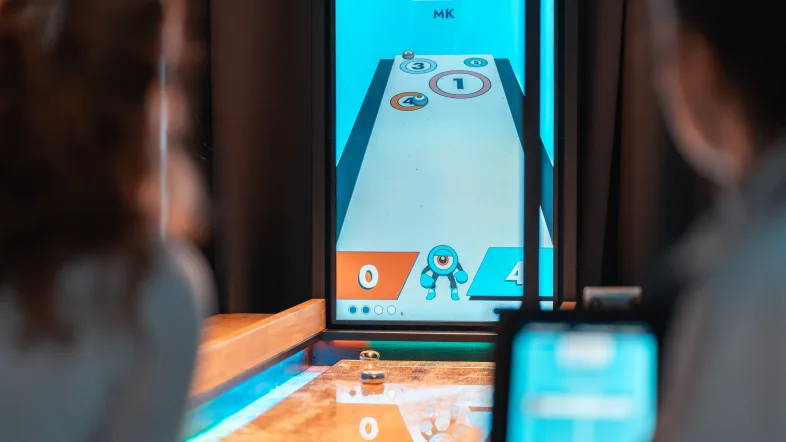 Zwei Personen vor einem Spieleautomaten