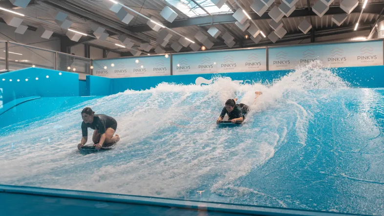 Zwei Personen auf Surf-Welle