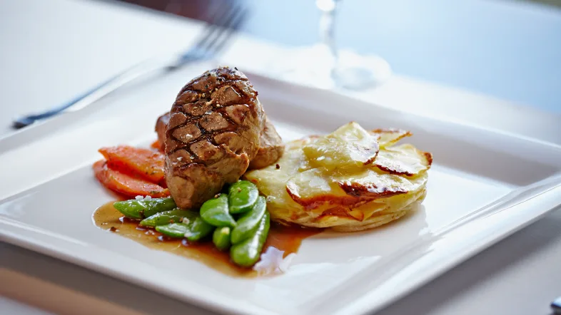 Teller mit Fleisch, Bohnen und Kartoffelgratin
