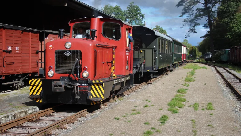 Diesellok Nahmer hat mit einem Personenzug den Bahnhof Hüinghausen erreicht.
