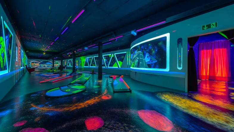 Innenansicht der Halle im Schwarzlicht-Semester Essen mit Neonbeleuchtung.