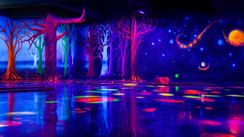 Schwarzlicht-Waldinstallation mit leuchtenden Pflanzen und Bäumen im Schwarzlicht-Semester in Essen