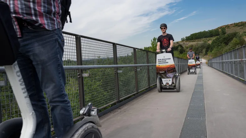 Segway-Fahrer überqueren eine Brücke auf der Halde Hoheward in Herten.