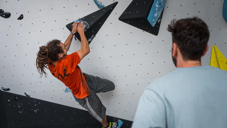 Mann klettert an Boulderwand.